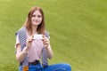 Female hand holding business card. Mockup of paper card note on green leaves background. Royalty Free Stock Photo