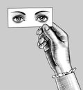 Female hand holding a card with eyes drawing