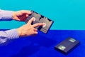 Pop art photography. Female hand holding cassette for video recorder  on blue background. Vintage, retro fashion Royalty Free Stock Photo