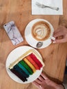 Female hand holding coffee cup and cake plate