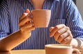 Female hand holding coffee cup over table in cafe, close up Royalty Free Stock Photo