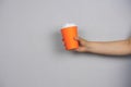 hand holding coffee to go blank cup against concrete gray wall copy space Royalty Free Stock Photo