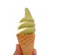 A female hand holding a cone of matcha-milk ice cream on white isolated background with copy space