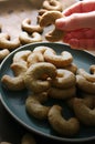 Female hand holding cookie, close up, walnut cookies on green plate Royalty Free Stock Photo