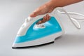 Female hand holding electric steam iron