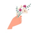 Female hand holding elegant small bouquet of delicate wild flowers. Beautiful spring bunch of anemones and green twigs Royalty Free Stock Photo