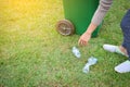 Female hand holding empty bottle into the trash