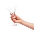 Female hand holding empty clean martini glass against white Royalty Free Stock Photo