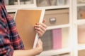 Female hand holding a empty space book in her hand preparing to arrange in the file folder on the document cupboard at the office Royalty Free Stock Photo