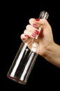 Female hand holding empty vodka bottle isolated on the black background Royalty Free Stock Photo