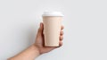 Female hand holding empty white blank paper cup of coffee with a cap. Isolated on white background with copy space Royalty Free Stock Photo