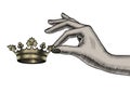 Female hand holding in fingers a gold crown