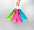 female hand holding four colored paper shopping packaging bags Royalty Free Stock Photo