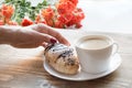 Female hand holding freshly baked chocolate croissants and cup of coffee. Breakfast concept. Royalty Free Stock Photo