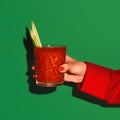 Female hand holding glass with cocktail bloody mary  on bright green neon background. Concept of taste Royalty Free Stock Photo