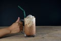 Female hand holding glass of ice coffee