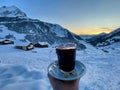 Female hand holding glass of mulled wine on a sunny winter day in idyllic Partnun, Graubuenden, Switzerland. Royalty Free Stock Photo