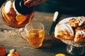 Female hand holding glass teapot and pouring hot aromatic tea to the cup Royalty Free Stock Photo