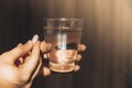 Female hand holding glass of water and pink pill. Collagen supplement for nutrition. Healthy eating lifestyle. Taking Royalty Free Stock Photo