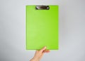 female hand holding a green clipboard  for clamping papers Royalty Free Stock Photo