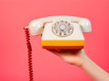 Female hand holding handset of vintage phone. cropped view of girl holding vintage rotary phone at ultra violet wall Royalty Free Stock Photo