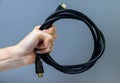 female hand holding hdmi cable on gray background isolated Royalty Free Stock Photo