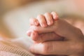 Female hand holding her newborn baby hand. Mom with her child. Maternity, family, birth concept Royalty Free Stock Photo