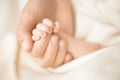 Female hand holding her newborn baby`s hand. Mom with her child. Maternity, family, birth concept. Copy space for your Royalty Free Stock Photo