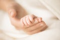 Female hand holding her newborn baby`s hand. Mom with her child. Maternity, family, birth concept. Copy space for your