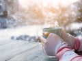 Female hand holding hot cup of coffee in winter Royalty Free Stock Photo