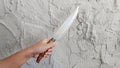 female hand holding a huge sharp knife. Isolated on the cement background Royalty Free Stock Photo