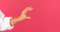 Female hand holding invisible object over pink background Royalty Free Stock Photo