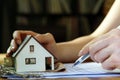 Female hand holding keys next to a miniature house - real estate business concept Royalty Free Stock Photo