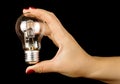 Female hand holding lamp isolated on the black background Royalty Free Stock Photo