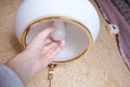 Female hand holding a led light bulb to change, replace it at home, screwing in the bulb into a lamp holder for energy Royalty Free Stock Photo