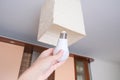 Female hand holding a led light bulb to change, replace it at home, screwing in the bulb into a lamp holder for energy saving and Royalty Free Stock Photo