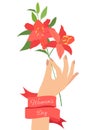 Female hand holding lily flower branch