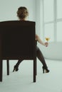 Female hand holding a martini glass while sitting in a chair Royalty Free Stock Photo