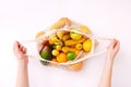 Female hand holding mesh eco bag with fruits on light background. Healthy clean eating. Eco shopping concept. Royalty Free Stock Photo