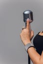 Female hand holding a microphone isolated on white background, clipping path. Royalty Free Stock Photo
