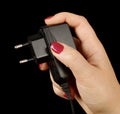 Female hand holding mobile phone charger Royalty Free Stock Photo