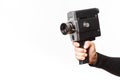 Female hand holding old style 8 mm movie camera on a white background Royalty Free Stock Photo