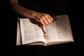 Female hand holding opened holy bible and crucifix. Royalty Free Stock Photo