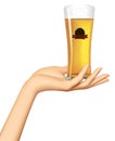 Female hand holding on the palm a glass with a beer and label