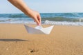 Female hand holding paper boat on the sea background Royalty Free Stock Photo