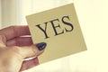 Female Hand Holding Paper with Yes Letter. Royalty Free Stock Photo