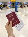 female hand holding passport citizen Russia, air tickets, documents in airport waiting room, check-in passengers for flight,