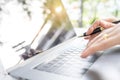 Female hand holding pen typing on laptop key board on table with Royalty Free Stock Photo