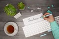 Female hand holding a pen and writing `freelance` in notepad. Business flat layout Royalty Free Stock Photo