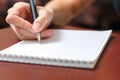Female hand holding a pen and writing in a notebook Royalty Free Stock Photo